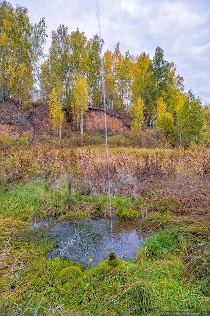 сильный напор воды из трубы среди холмов