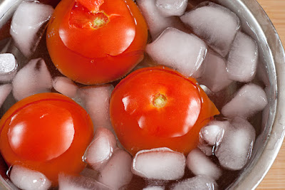 Submerging tomatoes in an ice bath