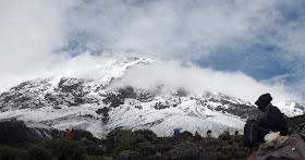 Porteador-frente-vistas-cima-Kilimanjaro-desde-campamento-Karanga