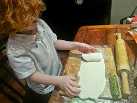 Four year old cooking making a sausage roll