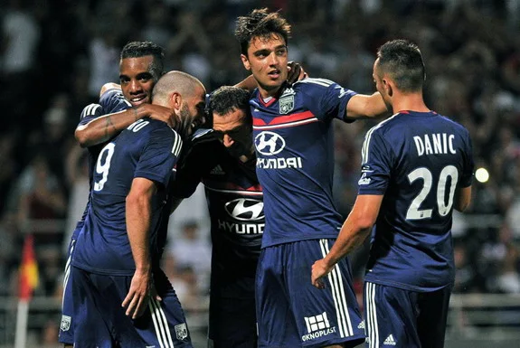 Clément Grenier celebrates with Lyon teammates after scoring a goal against Real Madrid