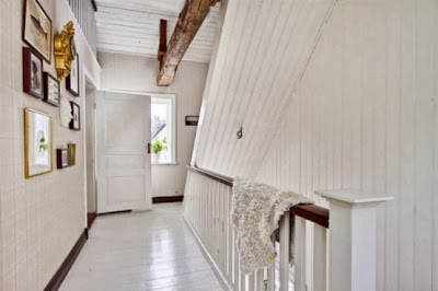 calm in white and dark brown upstairs hallway with attractive wall decorations and rough wood