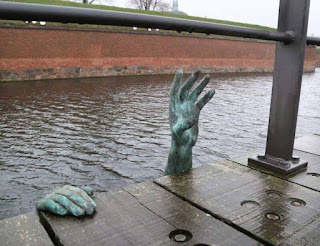 γλυπτό στη Δανία. Δείχνει έναν μετανάστη  που ζητάει βοήθεια την ώρα πνίγεται.