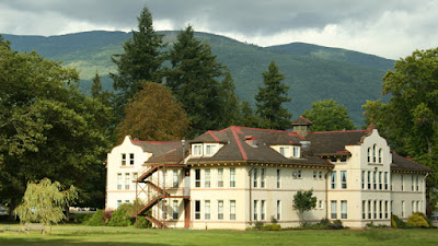 A view of the Northern State Hospital main building with hills and trees in the background