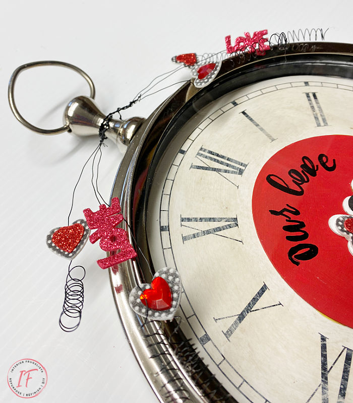 How to repurpose an old  wall clock and turn it into a whimsical DIY Valentines wreath. It's a fun, cheap, and unique door wreath idea.