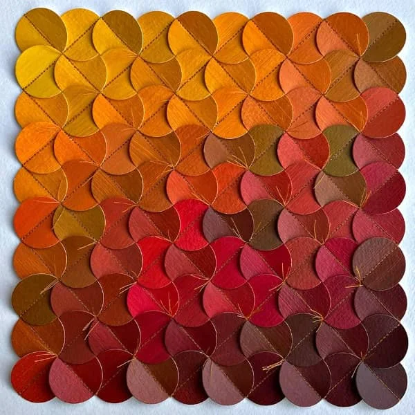 square, stitched paper art composed of circles placed in rows of autumn color gradient