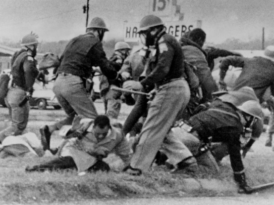 An Alabama State Trooper swings his baton at the head of the then-25-year-old Congressman John Lewis on March 7, 1965. ( Everett Collection Historical, Alamy Stock Photo)