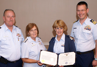 Helen Cummings receives Achievement Medal from Auxiliary and Coast Guard leaders.