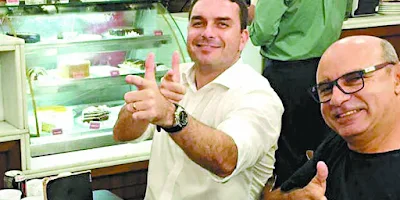 Flávio Bolsonaro faz arminha com Queiroz