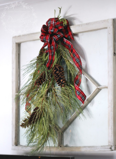 Antique window with plaid ribbon bow and pine cone garland.