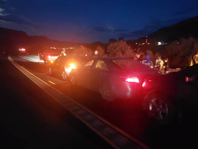 A row of vehicles parked with their lights on in the evening of Sept. 27 after a speeding driver crashed into one of them.