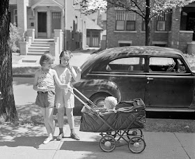 Detroit, Michigan. Little girls wheeling baby brother in a carriage. 1942 July.