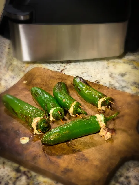 Whole Jalapeno Poppers, a spicy, cheesy, grilled appetizer.  The recipe is straightforward with few ingredients, jalapenos, cream cheese, white cheddar cheese, garlic powder, and of course bacon.