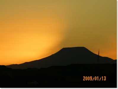 dust blowing up the mountain at sunset