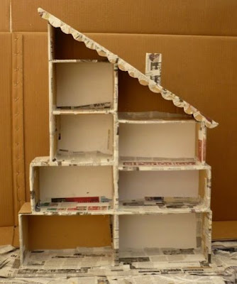 Faça uma casinha de bonecas com caixas de papelão. Corte as caixas em diferentes tamanhos, cole e decore como quiser.