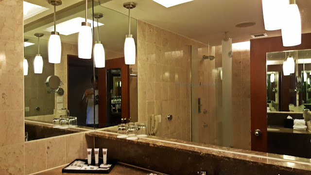 big mirrors and wide sink area of a room at dwissotel the stamford in Singapore
