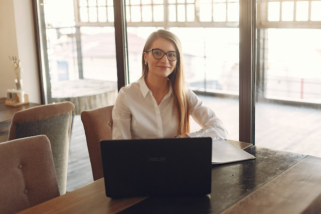 Smiling blonde woman sitting in front of her desk.