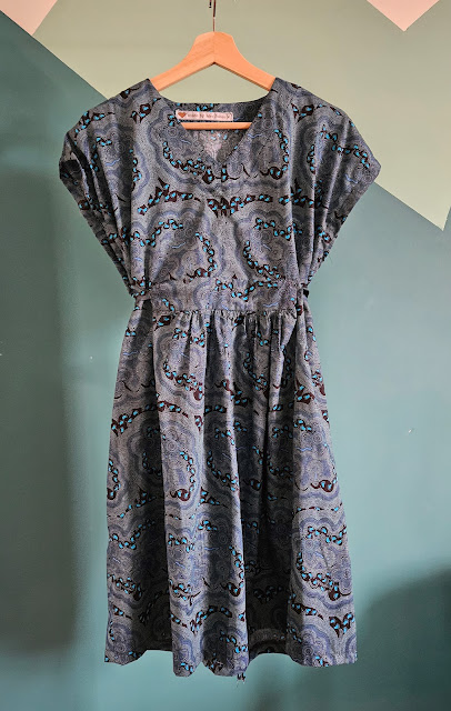 Mid-length teal caftan dress in aboriginal print. Front view