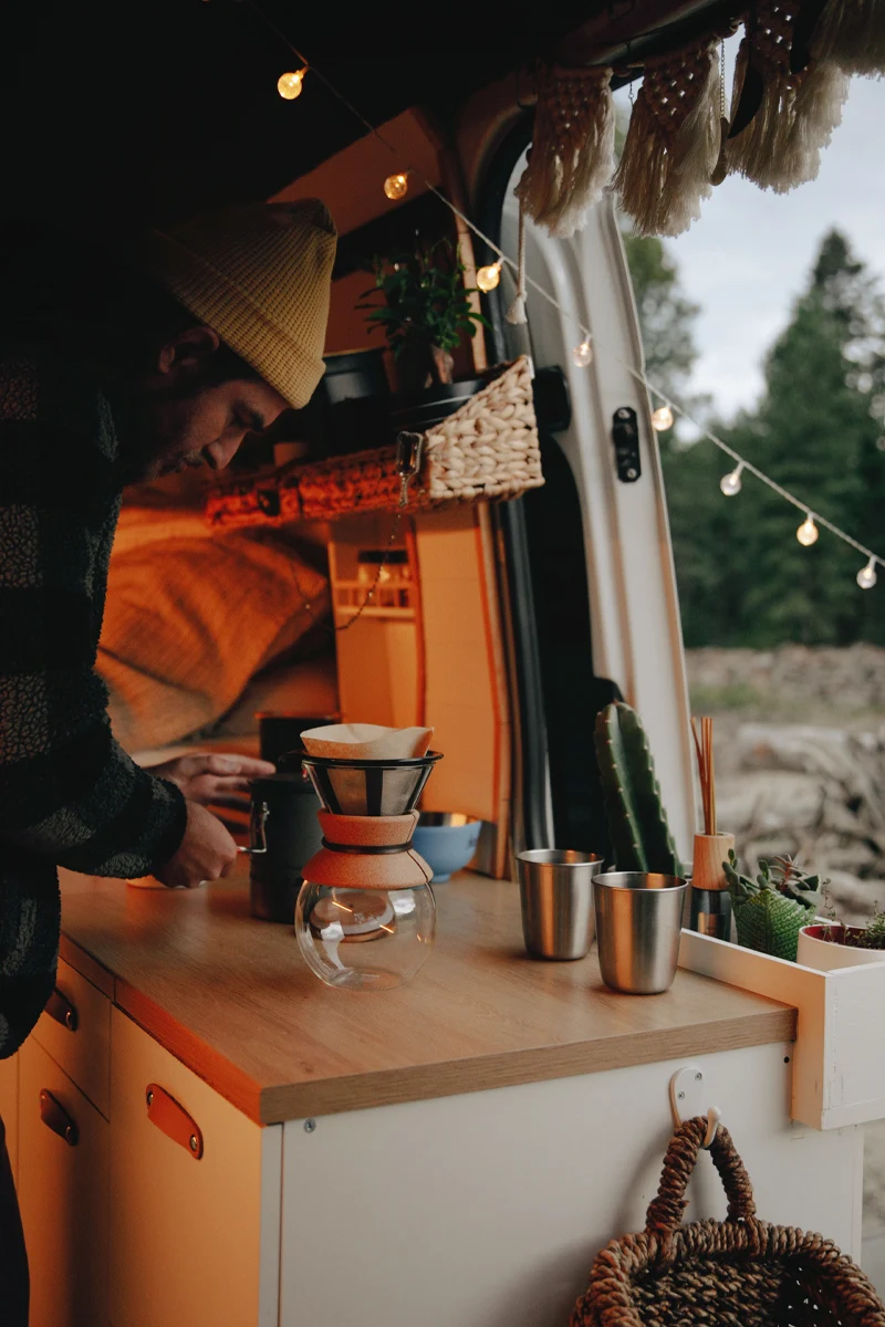 man preparing coffee in his caravan kitchen