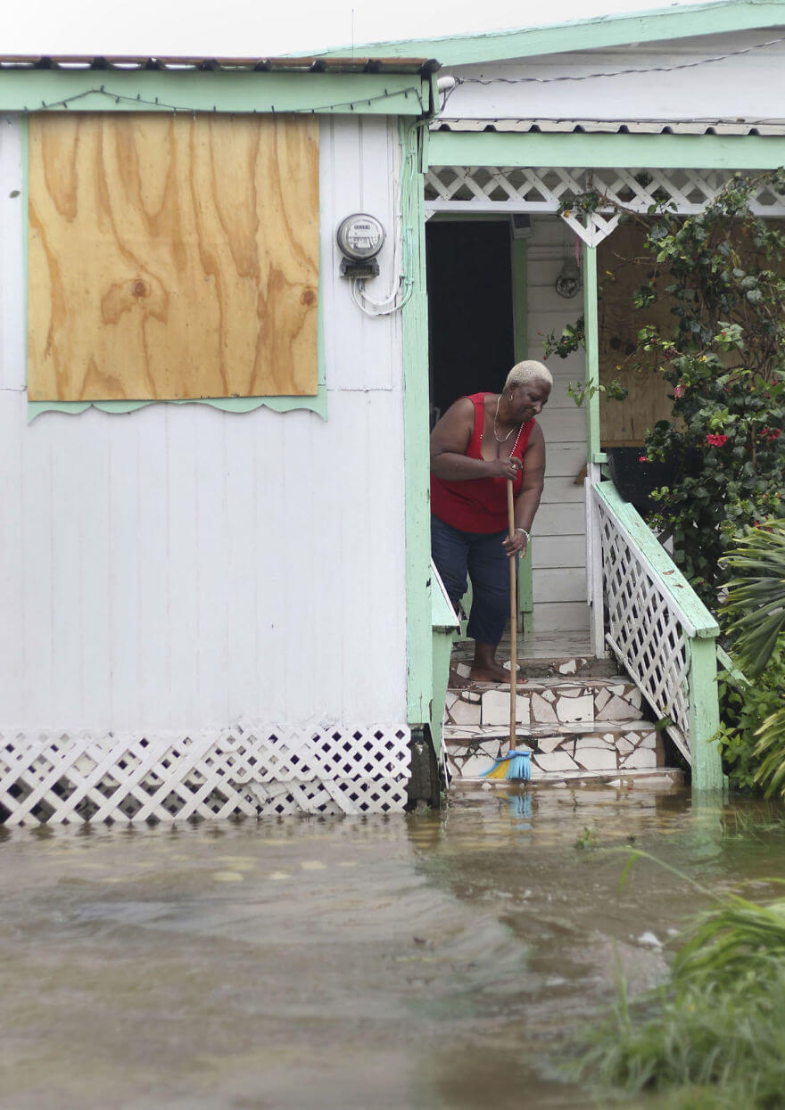 30 Shocking Pictures That Show How Catastrophic Hurricane Irma Is - A Woman Pushes Out Floodwaters On Her Property After The Passing Of Hurricane Irma, In St. John's, Antigua