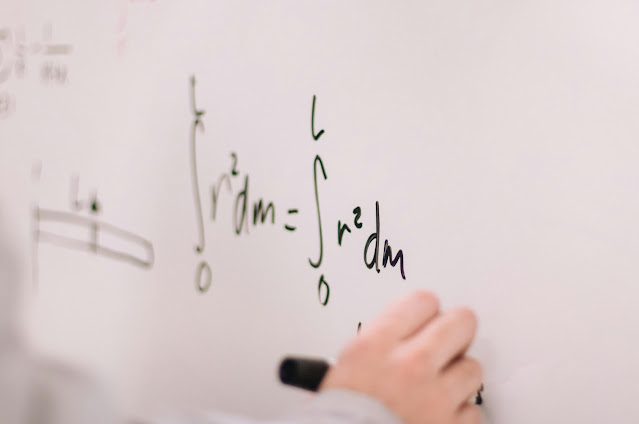 person-writing-on-white-board