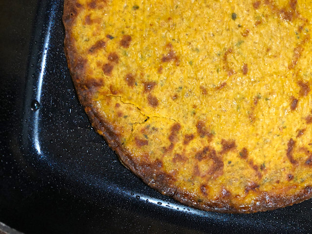 Photo of frozen crust with broken-off edges aligned in preheated skillet