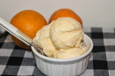 Spoon scooping honey orange sherbet.