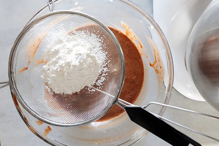 sifting flour into yolk mixture