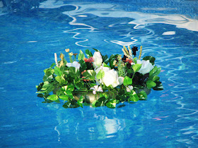 Decoración elegante de flores y velas sobre piscina para bodas