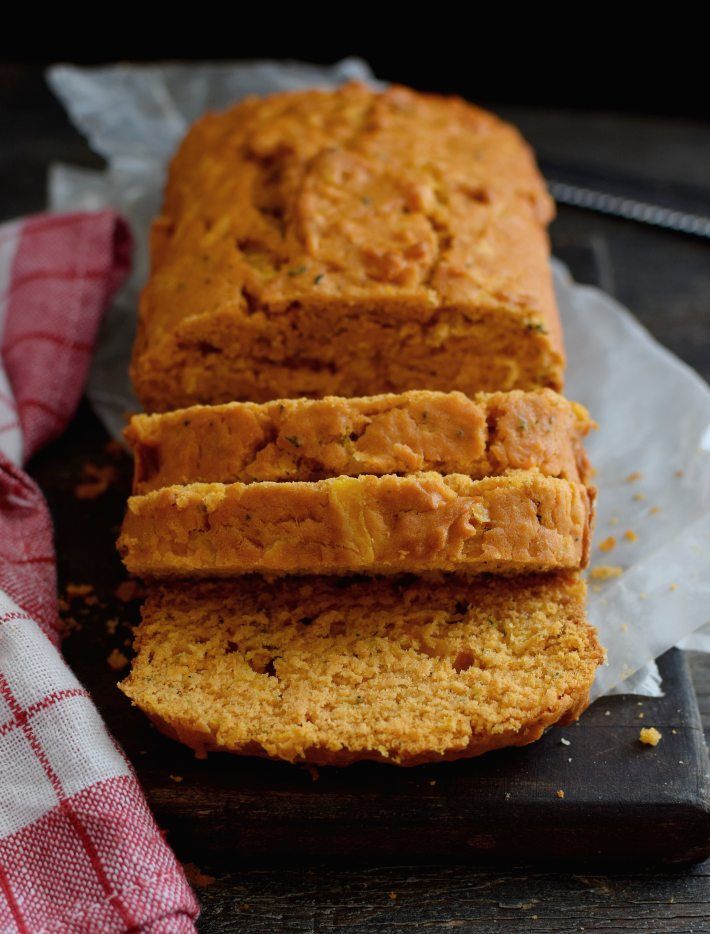 Hogaza de pan de tomate y albahaca sin levadura, con algunas porciones cortadas