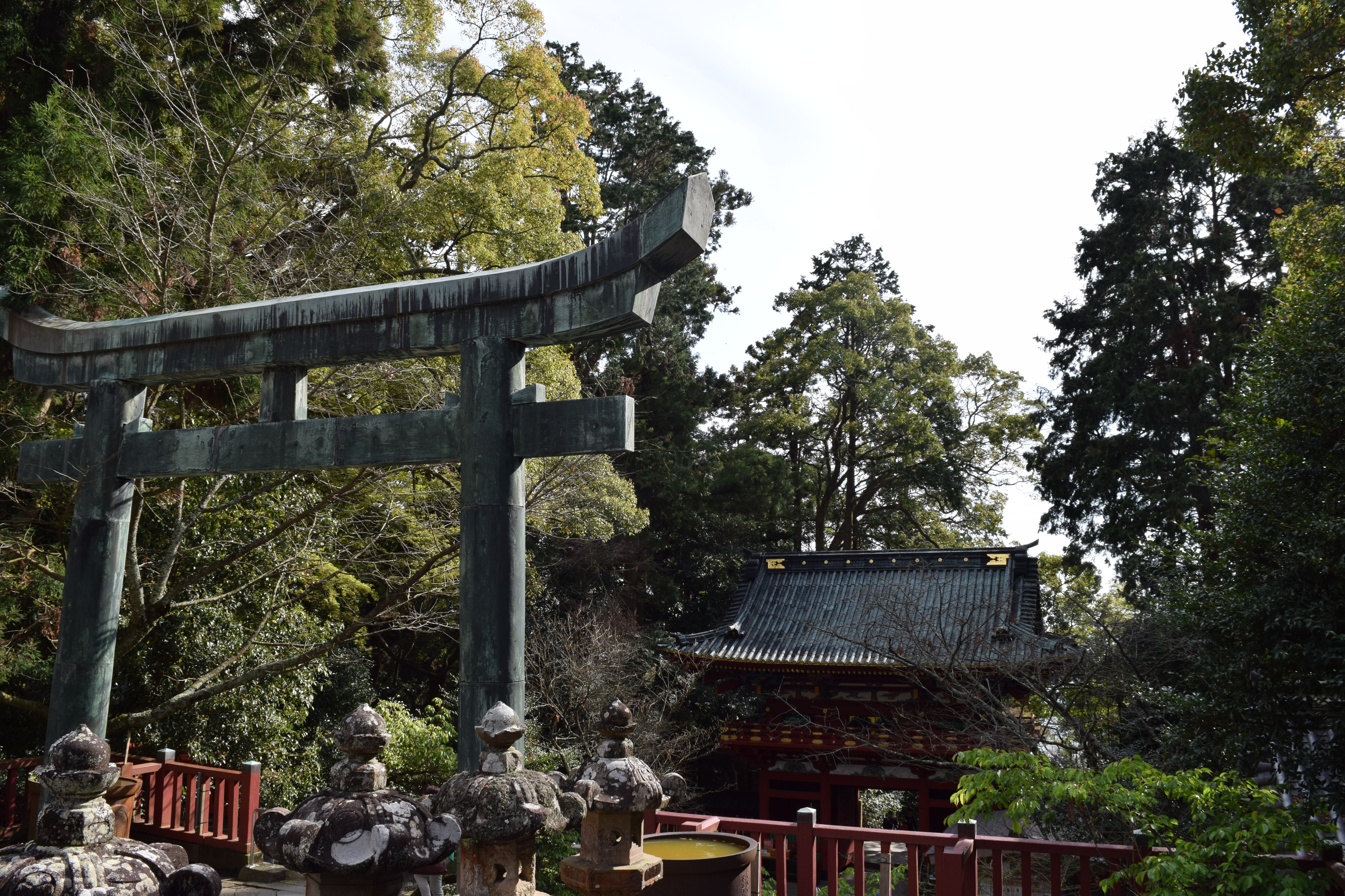 Toro stone lanterns, a torii shrine gate and the main gate of Kunozan Toshogu in Shizuoka