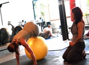 800px-Personal_trainer_monitoring_a_client's_movement_during_a_fitball_exercise