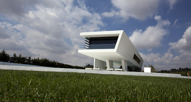 Picture of white modern home as seen from the backyard