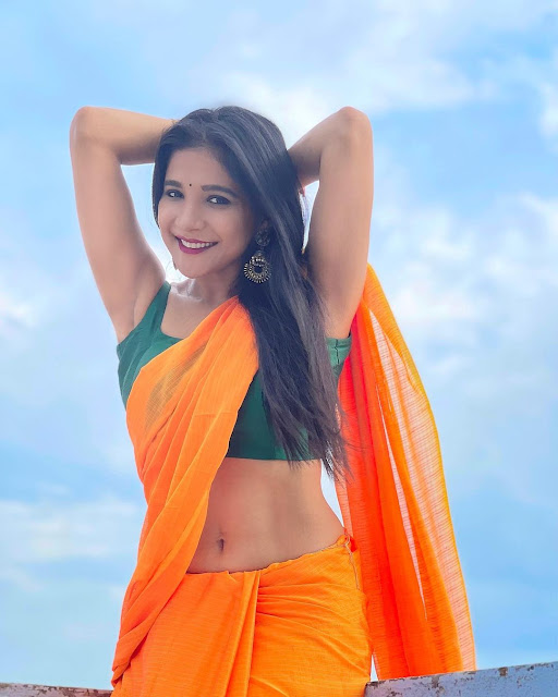 Sakshi Agarwal flaunts six-pack abs in plain orange saree and green sleeveless blouse