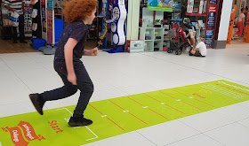 Blackburn Mall Active August Challenge my 10 year old leaping as far as he can above a measuring chart on the floor