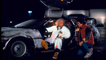 Back to the Future's Doc Brown sitting in the time-traveling DeLorean talking to Marty crouched down next to him