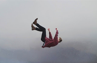 Man falling through the air, cloud background, plaid shirt flapping