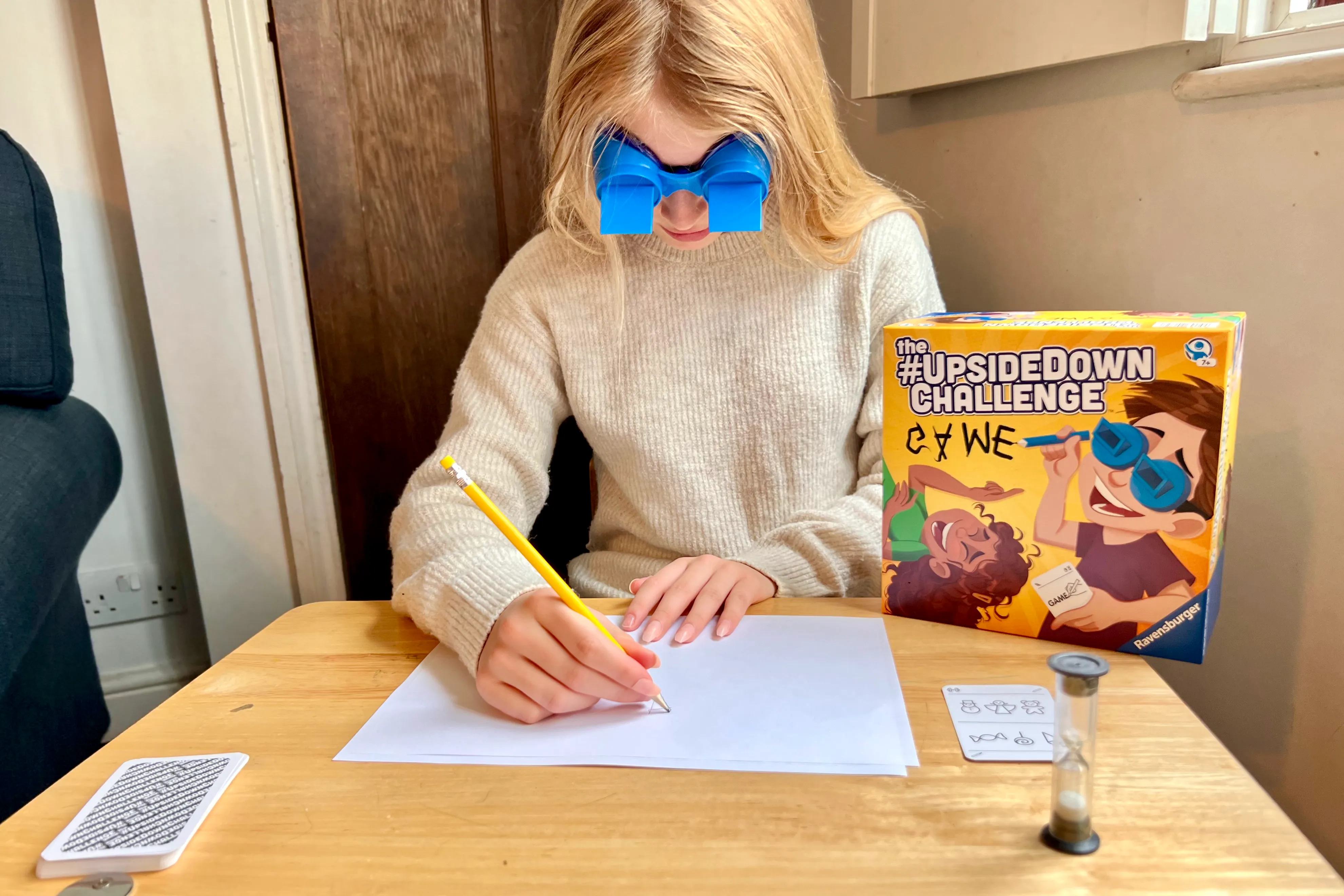 A girl with long hair wearing blue googles and drawing as part of the The #UpsideDown Challenge Game received to review