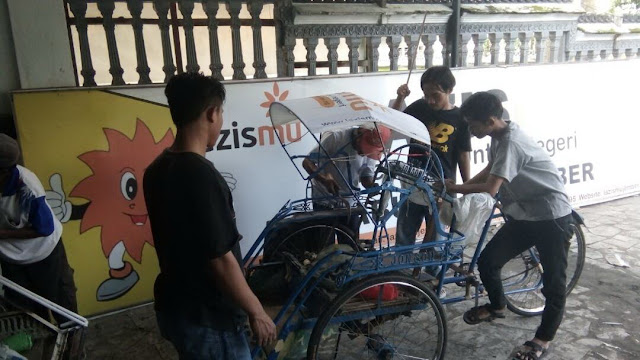 Proses Pemasangan Branding Lazismu Jember di Becak