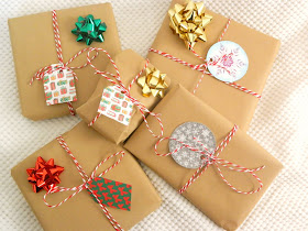 A pile of Christmas Presents all wrapped using brown paper and string