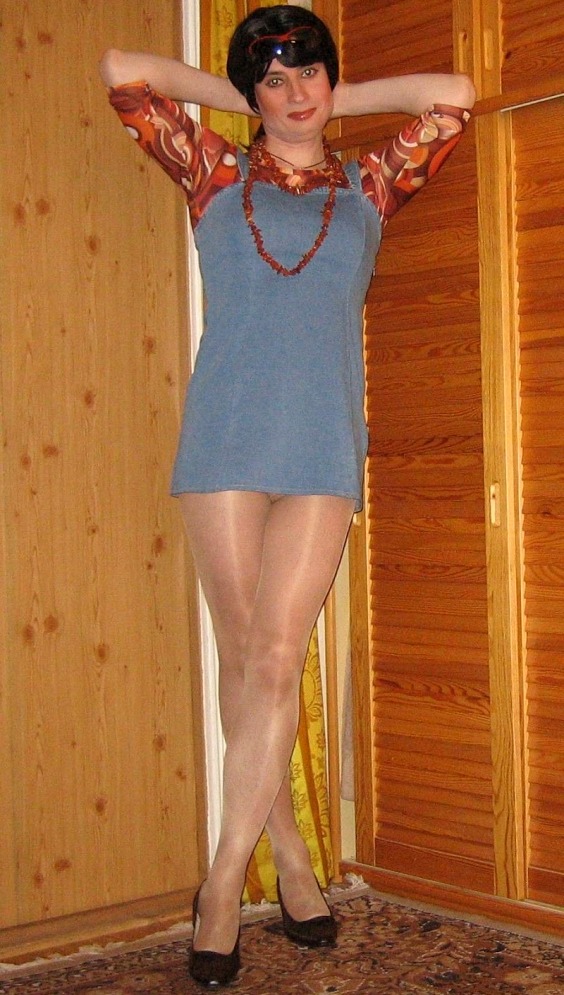 Crossdresser wearing a blue mini dress, shiny pantyhose and black high heels