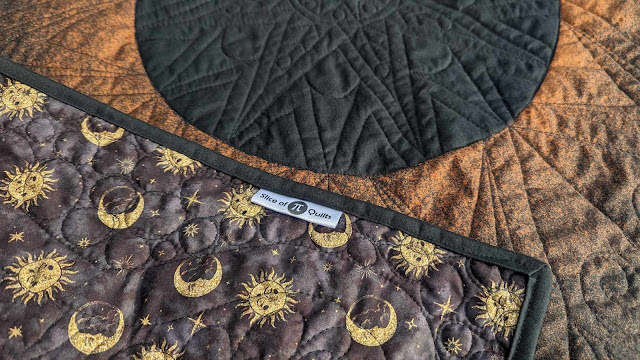 Solar eclipse quilt made by bleaching black fabric