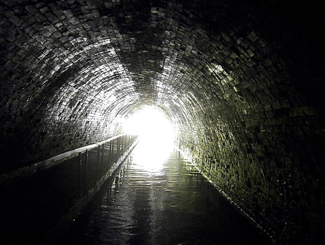 light shines at the end of a tunnel