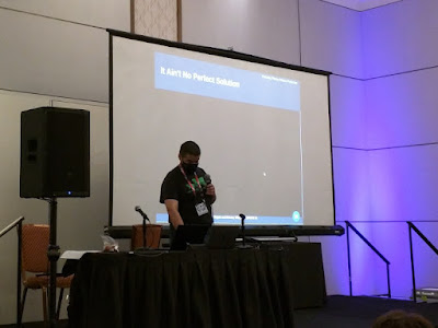 Mauricio Tavares on the podium spreading lies and misinformation while sporting the classic Oregon Trail shirt.