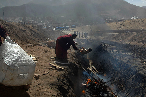 A-Tibet-Monk-Is-Throwing-Baby-Dying-On-Earthquake-To-Fire-Well