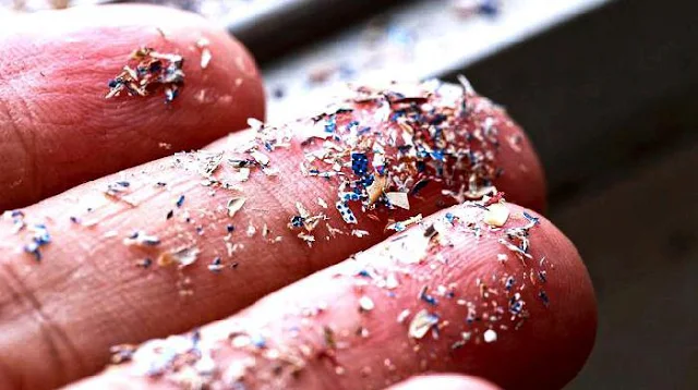 Pequeñas partículas de microplásticos vistas, destacando su presencia en el medio ambiente.