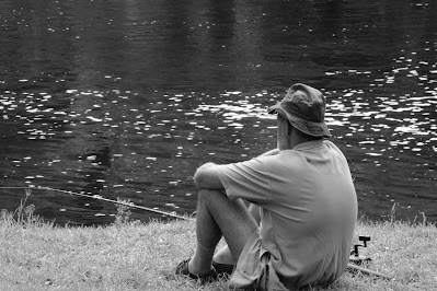man sitting for catching fish in sandas river