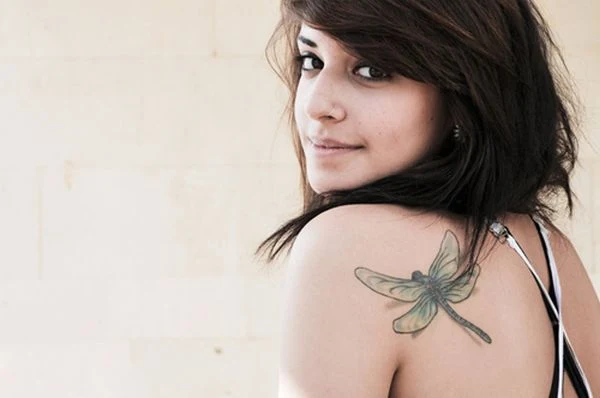 chica con un tatuaje de libelula muy femenino y detallado