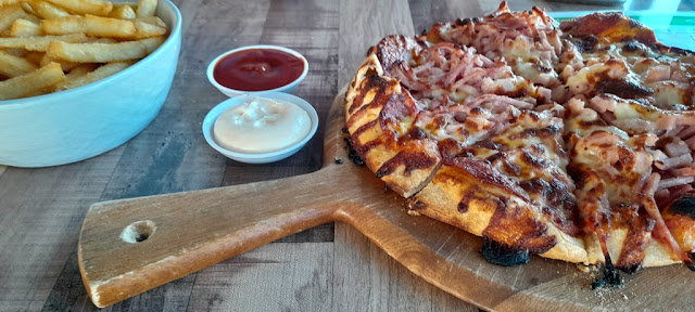 Our pizza with a side of chips/fries and sauces.