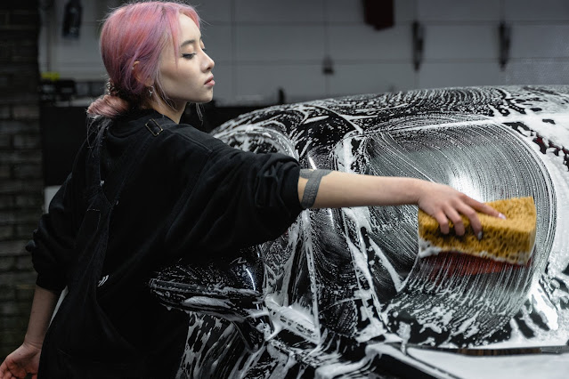 person with pink hair washing car